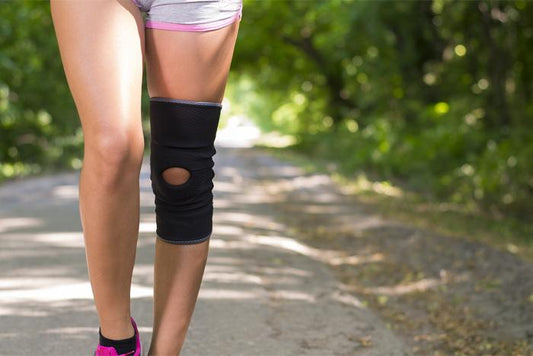 femme qui marche avec une genouillère de maintien au genou gauche